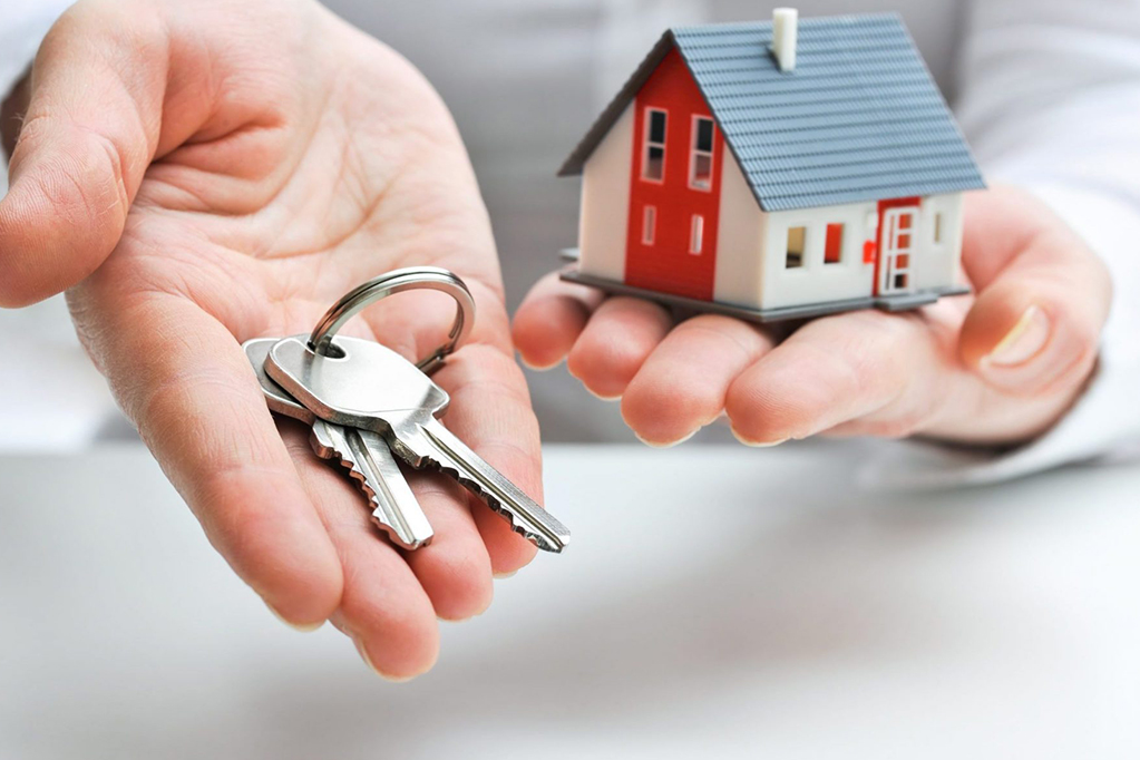 Real estate agent with house model and keys, close up